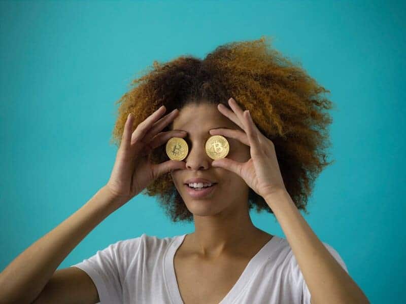 Žena drží dve Bitcoin mince