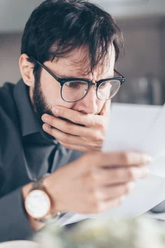 Muž sa tvári smutne pri čítaní pošty